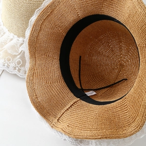 Detailed interior view of a knit straw sun hat with wavy lace trim and sweatband