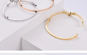 Dettaglio dei bracciali a forma di corna di cervo in argento, oro e oro rosa