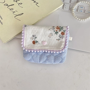 Detailed shot of floral quilted fabric storage pouch with pink heart button and purple pompom