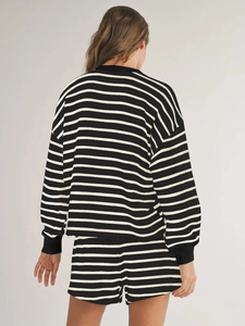 Rear view of women's black and white striped long-sleeve top and shorts set in soft knit