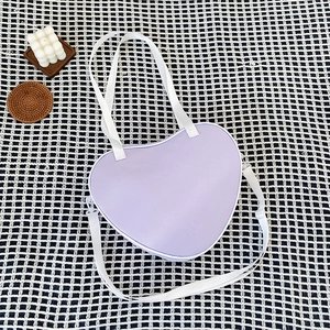 Lavender heart-shaped ita bag in PU leather on checkered background with candle