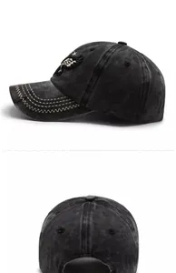 Detail view of washed black baseball cap featuring wing embroidery and side profile