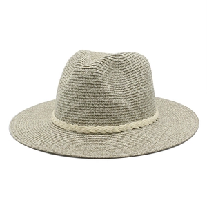 Gros plan sur la texture en paille beige et le ruban blanc d'un chapeau Panama