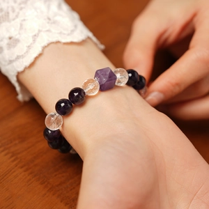 Gros plan d'un bracelet en améthyste et cristal carré porté sur un poignet féminin