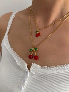 Detail einer zweilagigen Goldperlenkette mit Kirschanhängern an einem Modell