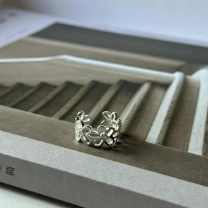 Macro shot of silver S925 sterling silver open ring featuring hollowed clover patterns