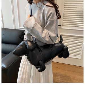 Detail of dachshund-shaped leather handbag with metal strap hooks and handle
