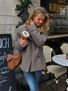 Close-up of brown plaid wool coat with notched lapels and buttoned cuffs for women