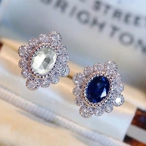 Macro shot of sapphire blue and white zircon flower earrings with oval cut gemstones