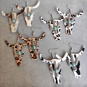 Detail of western cow head earrings with leopard print leather and turquoise accents