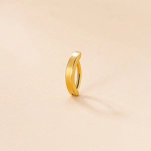 Minimalist gold stainless steel belly ring with smooth hinge on beige background