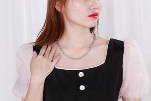 Collana in acciaio al titanio argento con maglie a infinito intrecciate su modella