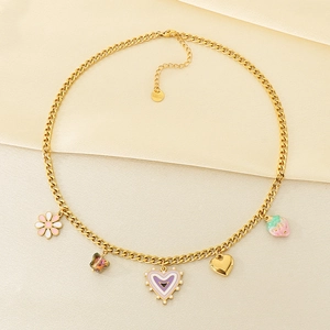 Détail du collier en acier inoxydable doré avec pendentifs fraise et cœur en émail