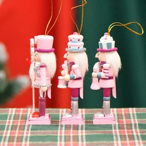 Pink Christmas nutcracker ornaments 3-piece set with cake hat on plaid tablecloth