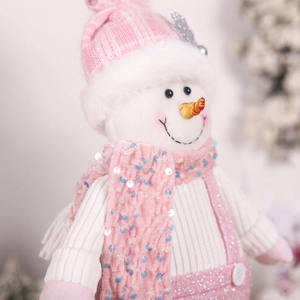 Close-up of pink Christmas snowman plush with sequin scarf and fine embroidery detail