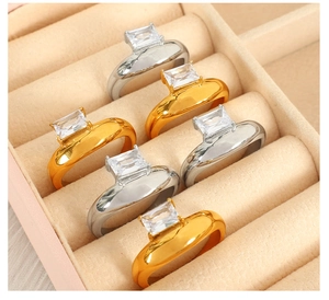 Detailed row of gold and silver irregular rings set with emerald-cut zircon stones