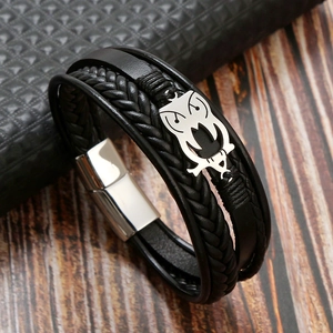 Detail of black braided leather bracelet with silver owl charm and magnetic closure