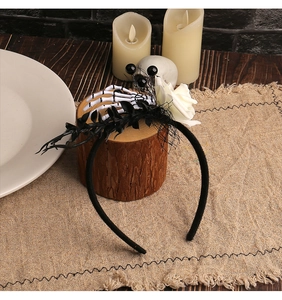 Close-up of Halloween gothic headband with skeleton hand, white rose and black mesh veil