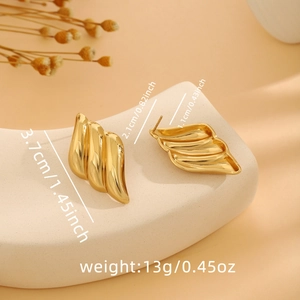 Macro detail of gold statement earrings with folded texture and dimension specs