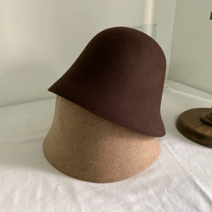 Détail de chapeaux cloche en feutre de laine marron et beige à texture épaisse