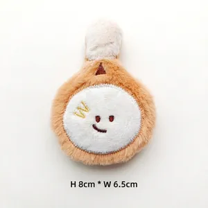 Plush cartoon racket accessory with embroidered smiling face and bone detail, 8cm x 6.5cm