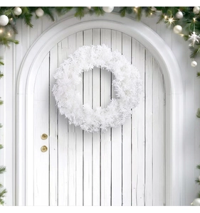 Close-up of fluffy white artificial pine Christmas wreath on a white wooden door