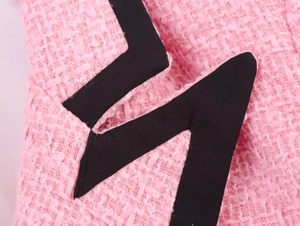 Detailansicht der rosa Tweed-Stofftextur mit einer schwarzen Zickzack-Applikation