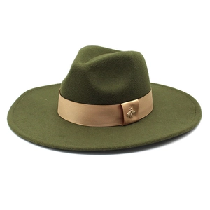 Detail of army green wool fedora hat featuring light brown ribbon and golden bee brooch