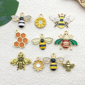 Detailed macro view of yellow and gold honeybee charms with sunflower and honeycomb shapes
