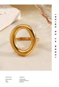 Polished 18K gold-plated chunky oval ring on a textured beige linen and stone background