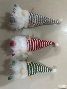 Close-up of three festive Christmas gnomes in silver, red, and green sequined hats
