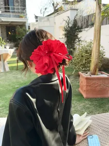 Close-up of red lace scrunchie with long ribbons worn on a ponytail in natural light
