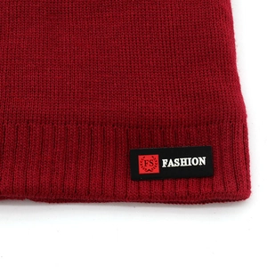 Winter knit beanie hat in burgundy with a stylish leather brand tag for outdoor warmth