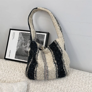 Detail of soft black and white striped plush hobo bag texture with a shoulder strap