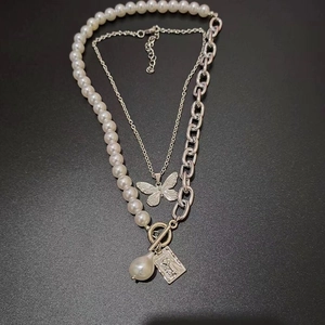 Double-layered necklace with butterfly pendant, baroque pearl and square relief medallion