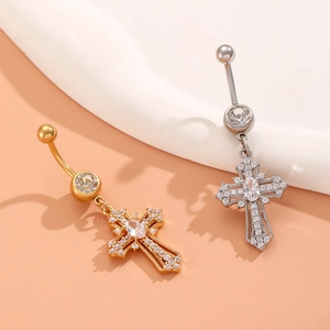 Detailed view of silver and gold heart cross navel rings with sparkling crystals