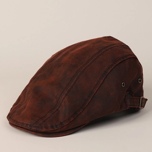 Close-up of vintage brown canvas flat cap with side metal eyelets and adjustable buckle