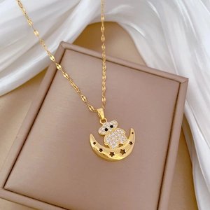 Close-up of golden moon and bear pendant encrusted with sparkling white rhinestones