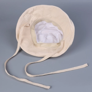 Detailed view of beige cotton sun hat interior with breathable mesh lining and tie straps