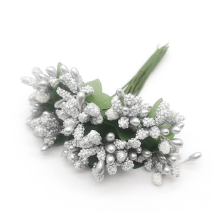 Close-up of silver simulation berry stems with green leaves for DIY floral decoration
