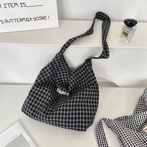 Dettaglio della borsa tote in tela a quadretti bianchi e neri con etichetta logo
