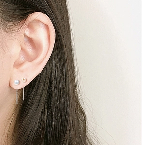 Detail of S925 silver threader earrings featuring two natural freshwater pearls on model