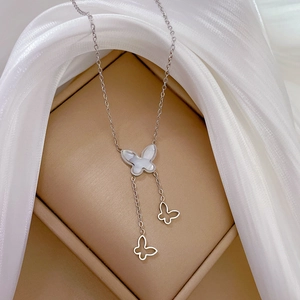 Detailed close-up of a titanium steel necklace with butterfly pendants and shell finish