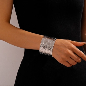 Detailed macro view of wide open silver metal cuff bracelet with hammered texture finish