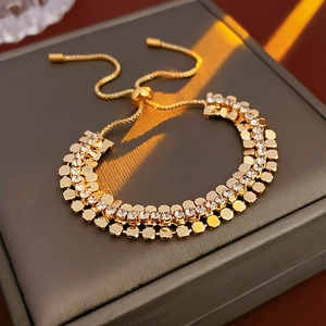 Détail d'un bracelet géométrique doré réglable avec des strass blancs brillants sur écrin