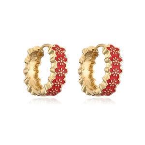 Detail of gold-plated hoop earrings with red enamel flower patterns and hinge closure