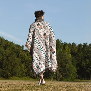 Close-up of bohemian woven camping blanket with ethnic geometric patterns and colorful tassels