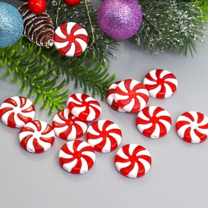 Christmas red and white peppermint swirl candy ornaments with festive pine tree decor