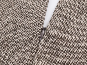 Macro view of high-quality invisible zipper on brown tweed wool dress fabric