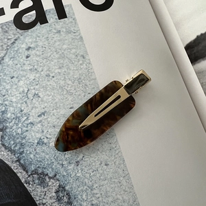 Macro shot of tortoiseshell acetate seamless hair clip on a fashion magazine background
